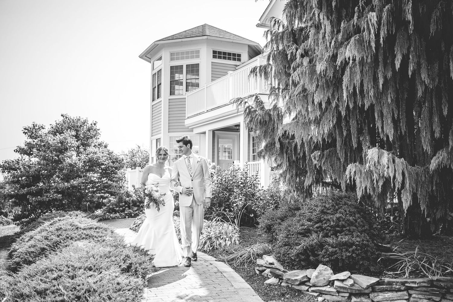 Elegant wedding photos taken outside a coastal home with weeping willow trees.