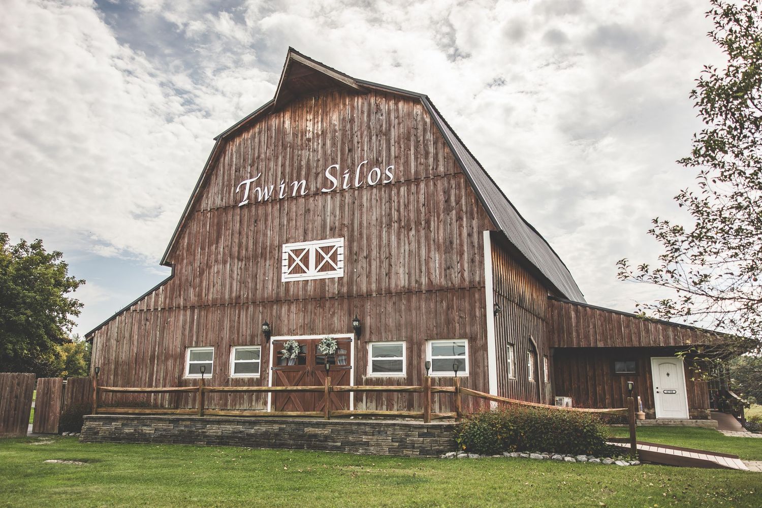 Exterior view of a classic wooden barn wedding venue in countryside setting.