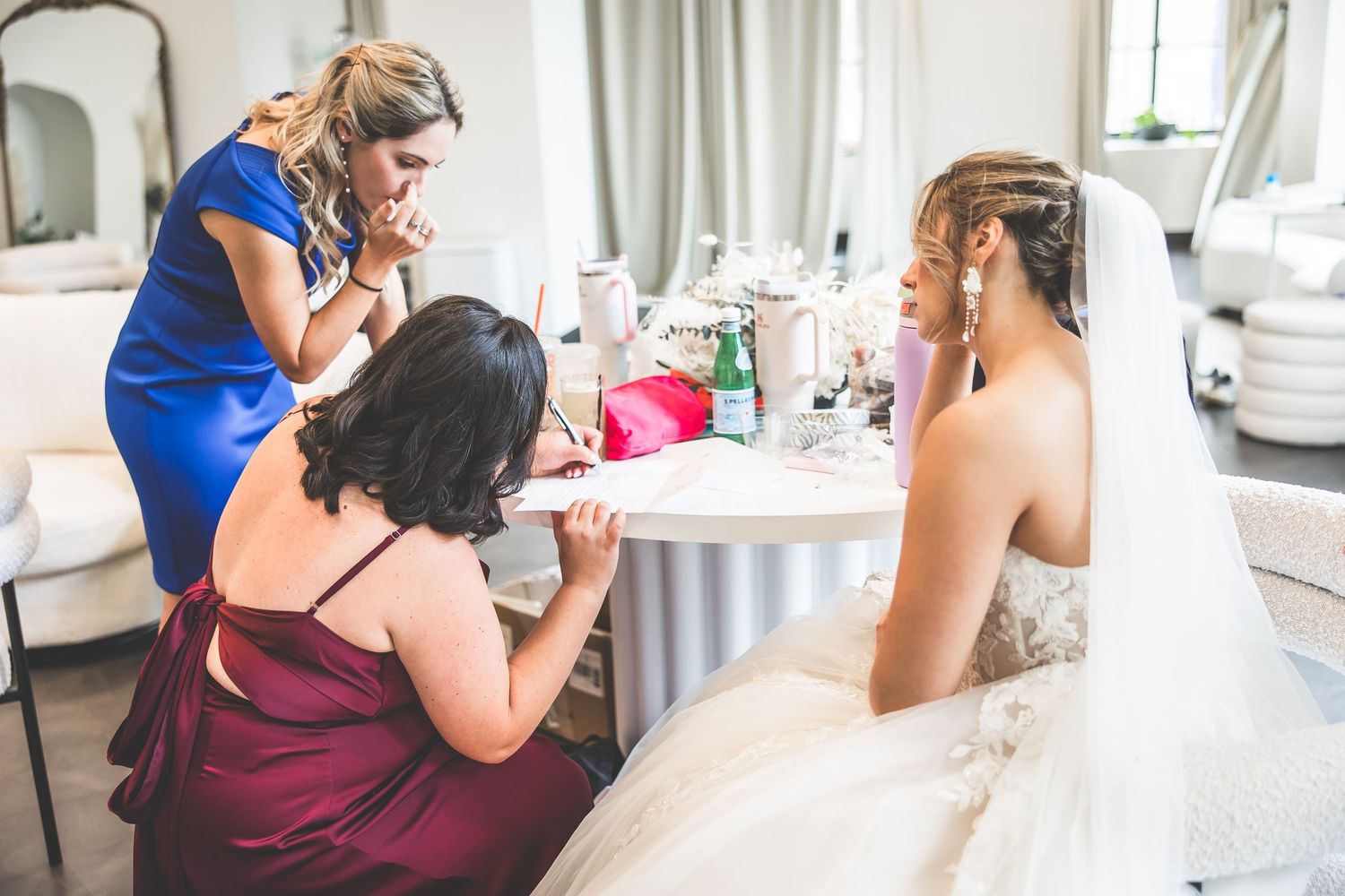 Wedding preparations in progress with bridal party getting ready at vanity table.