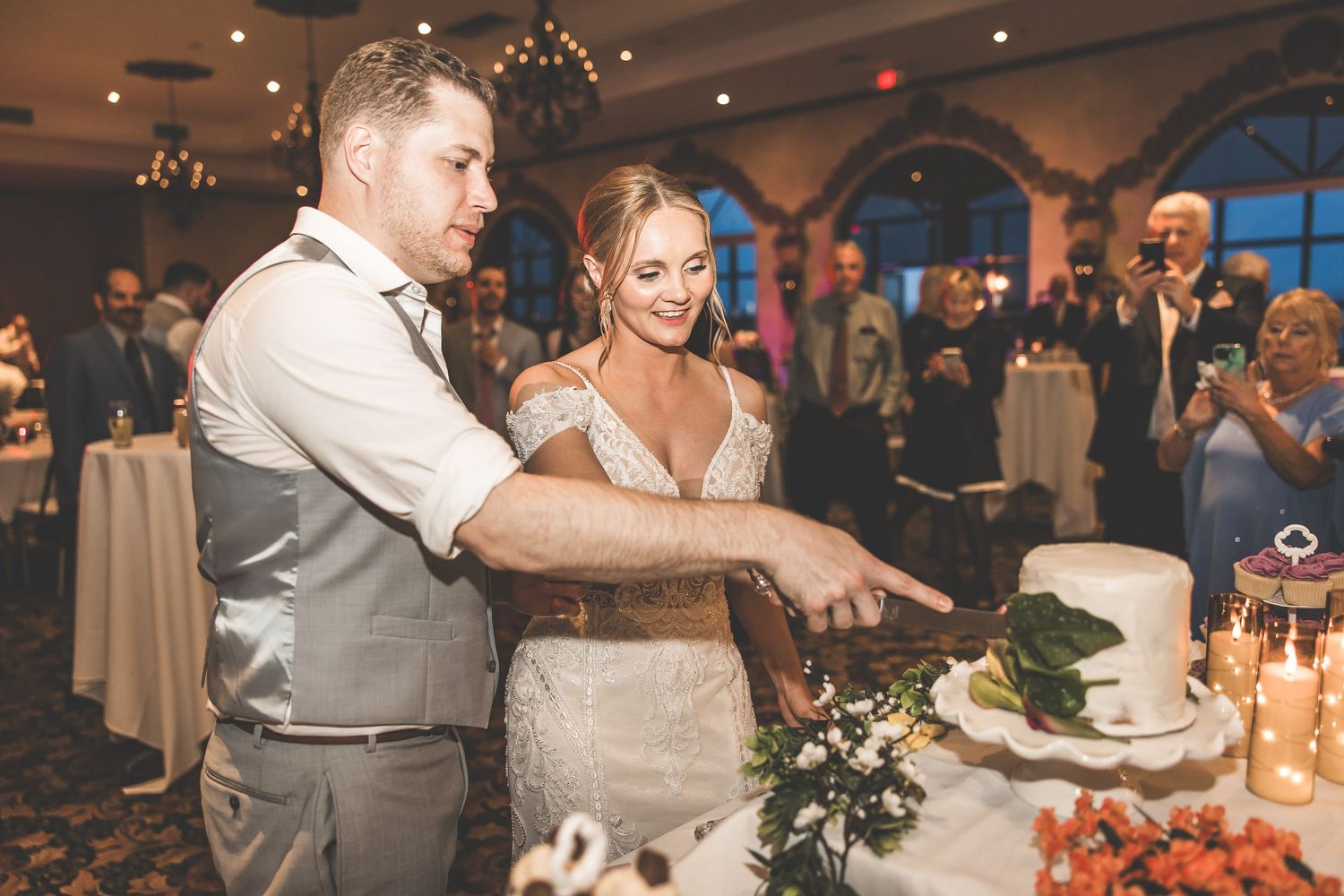 Wedding reception dining setup with decorated tables and centerpieces.