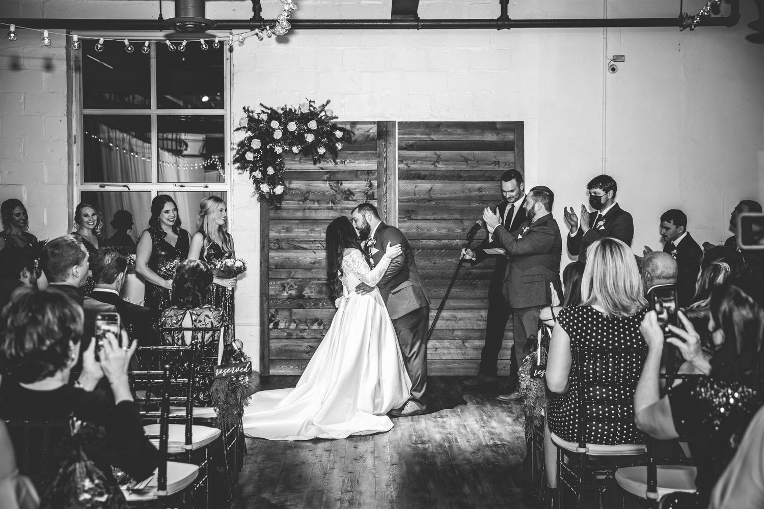 Black and white photo of wedding reception with guests seated at tables.