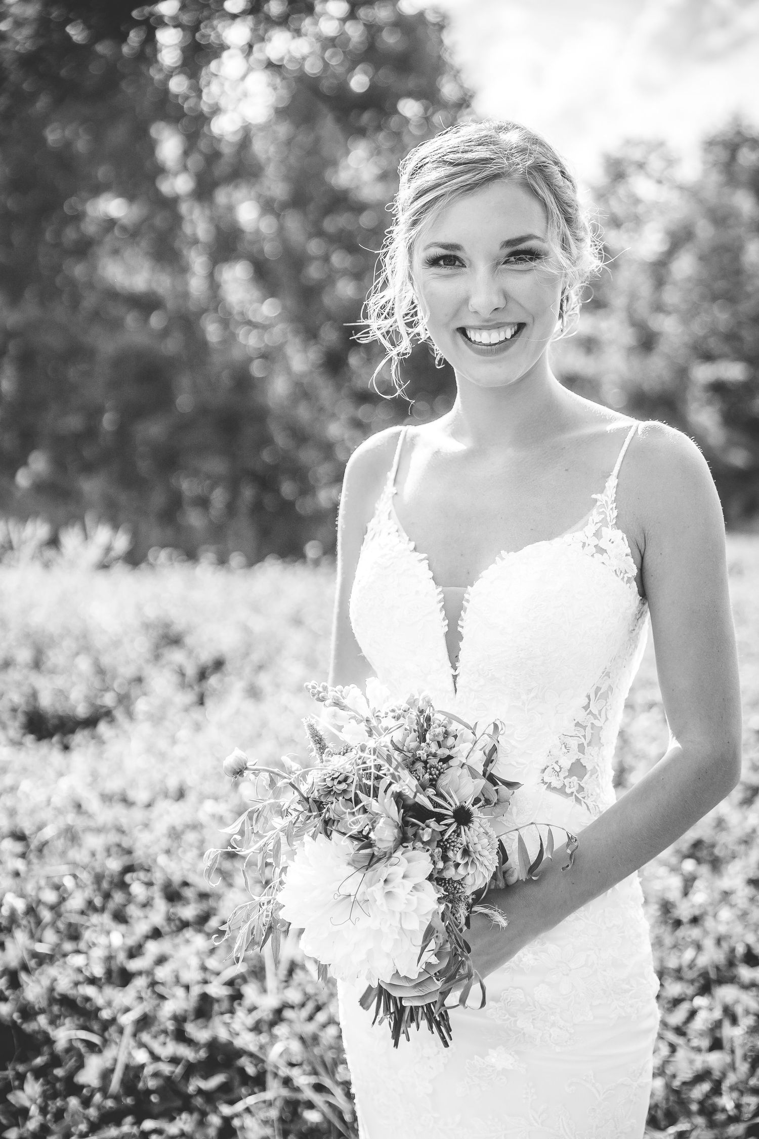 Black and white portraits of bride holding bouquet in sunny outdoor setting.