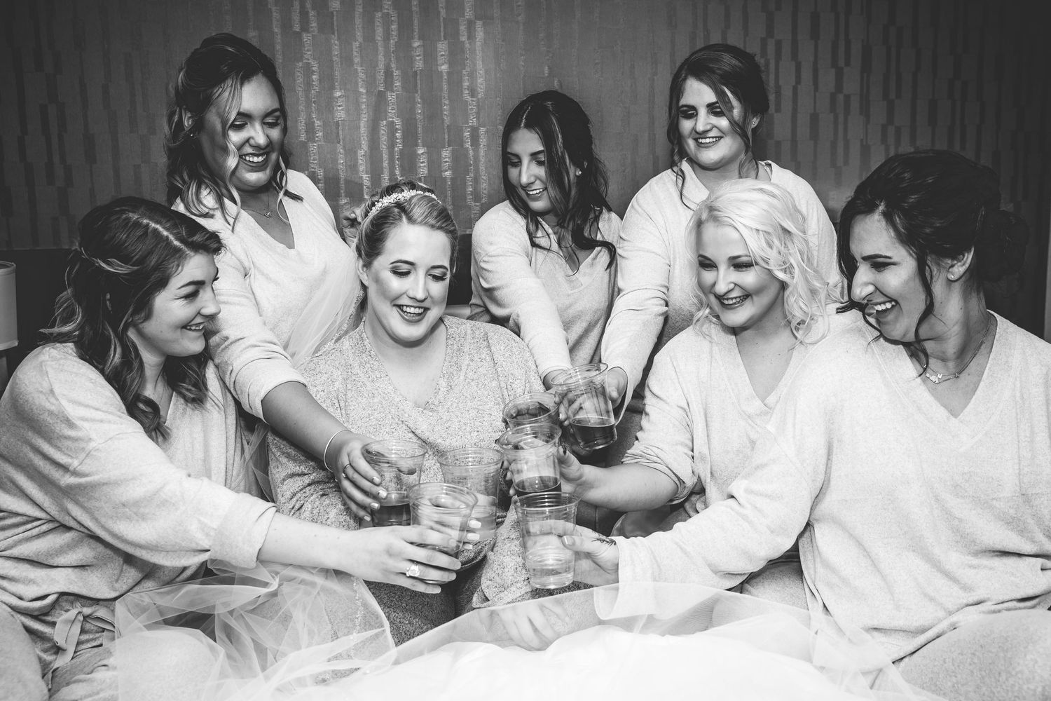 Group sitting together in black and white casual portrait style.