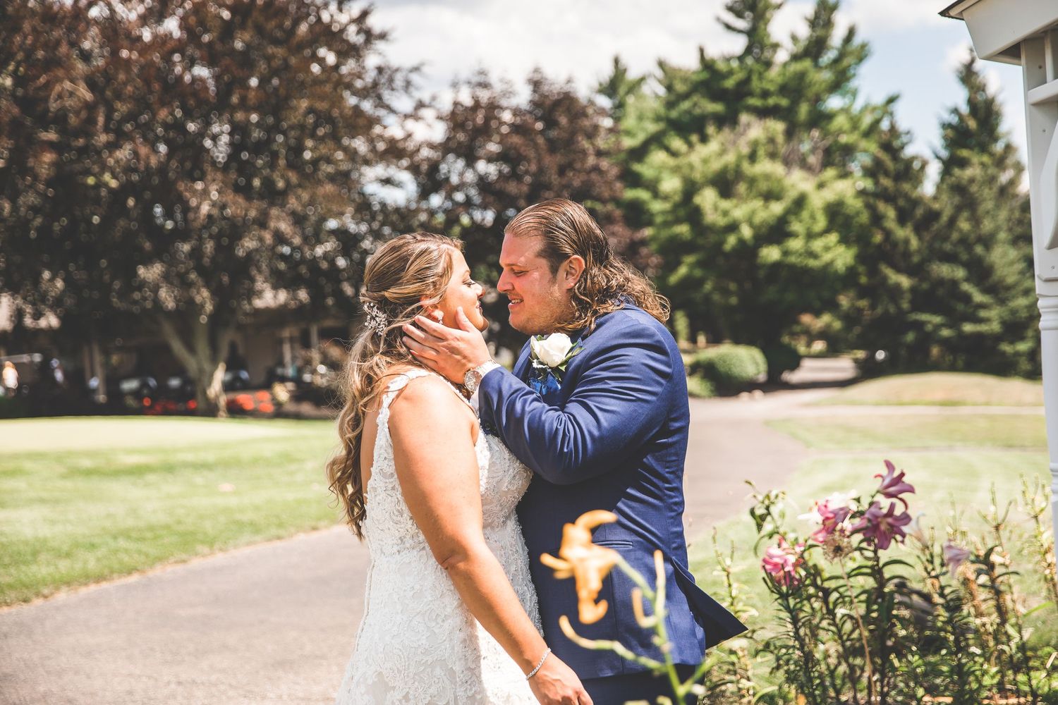 Couple sharing emotional first look moment in outdoor garden setting.