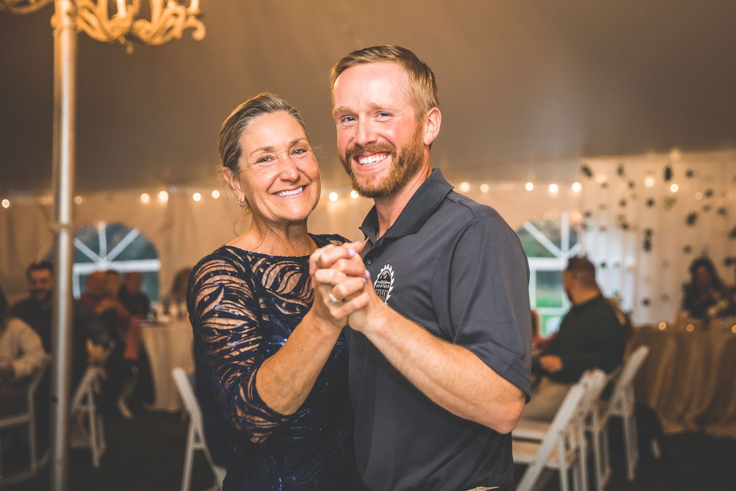 Joyful candid moments shared between dancing partners at a wedding reception.