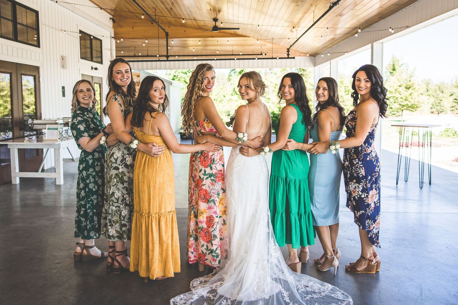 Wedding party gathering under a covered wooden porch area with natural lighting.