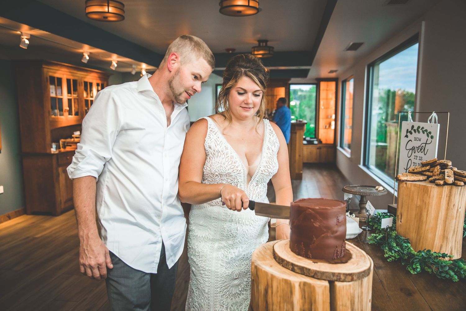 Couple sharing intimate dance moments at rustic wedding venue with wooden beams and ambient lighting.