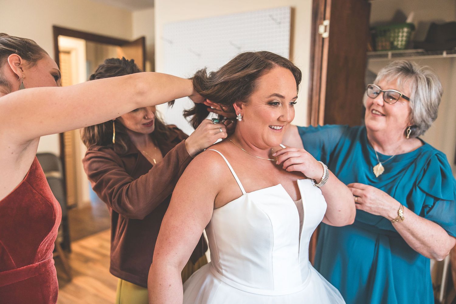 Candid emotional moments shared during wedding preparations in a bright indoor setting.