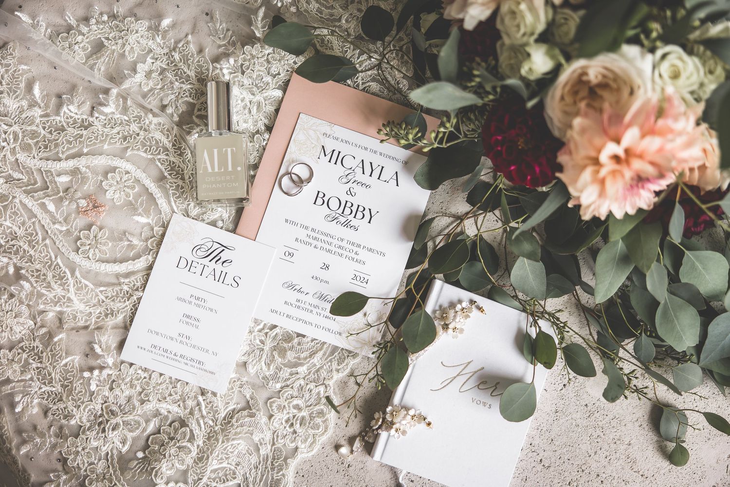 Wedding invitation suite with floral details and delicate lace accents on light background.