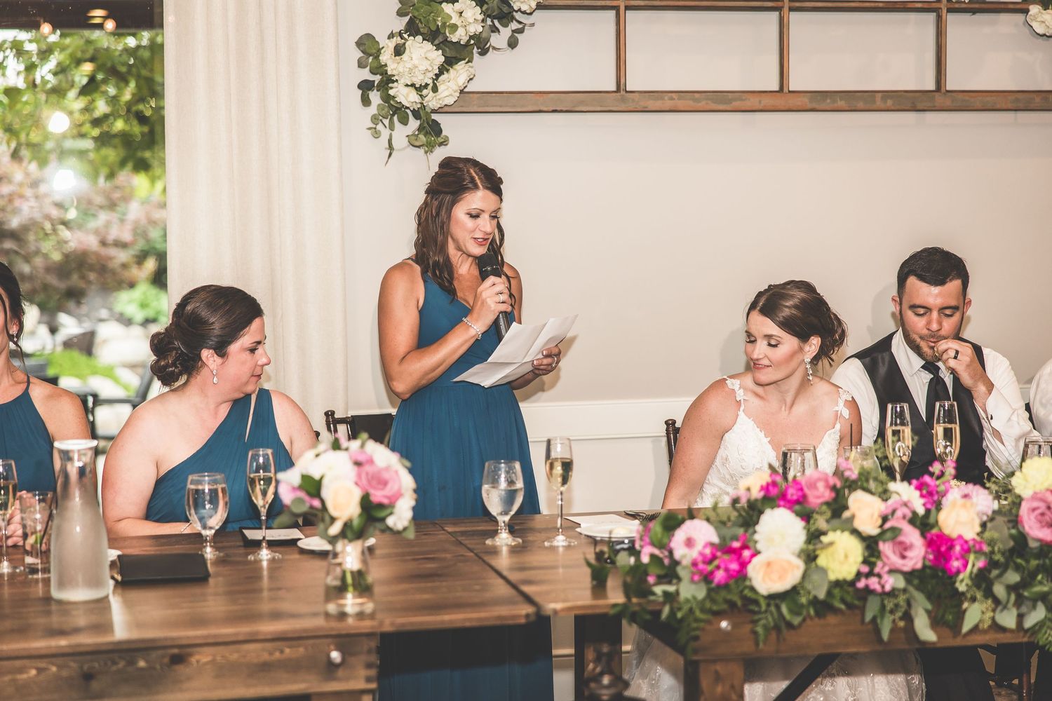 Elegant wedding reception setup with long wooden tables and floral centerpieces.