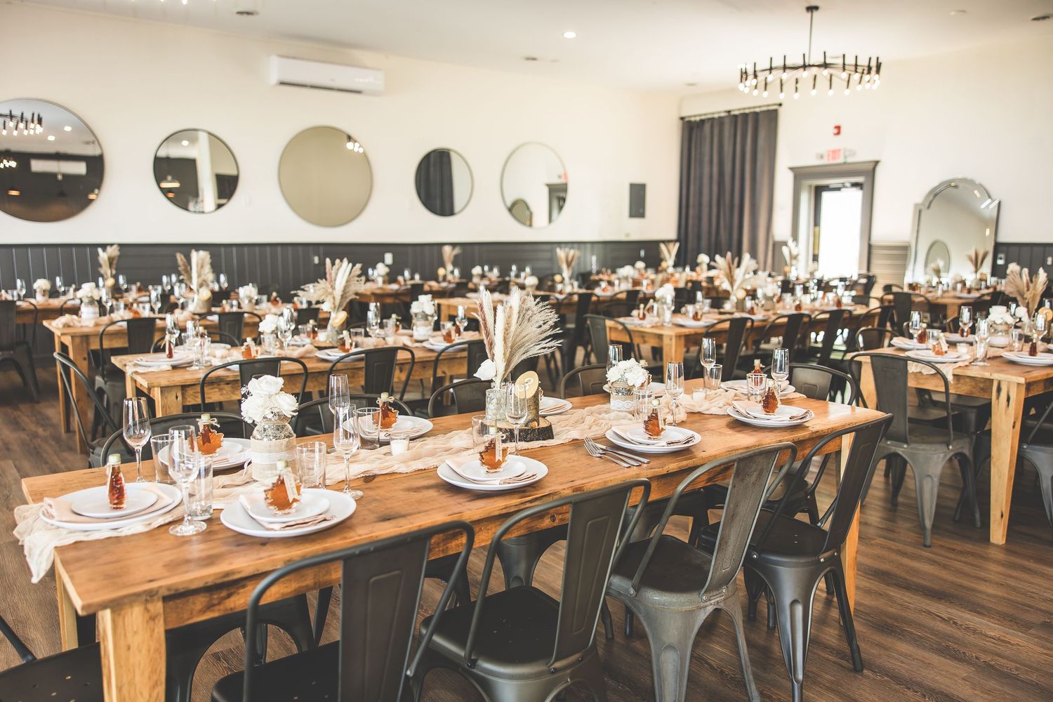 Elegant wedding reception venue with tables set for dining under crystal chandeliers.