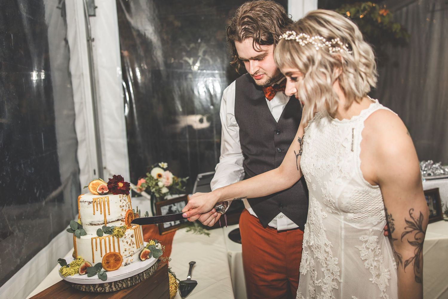 Wedding couple cutting their elegant white tiered cake at the reception.