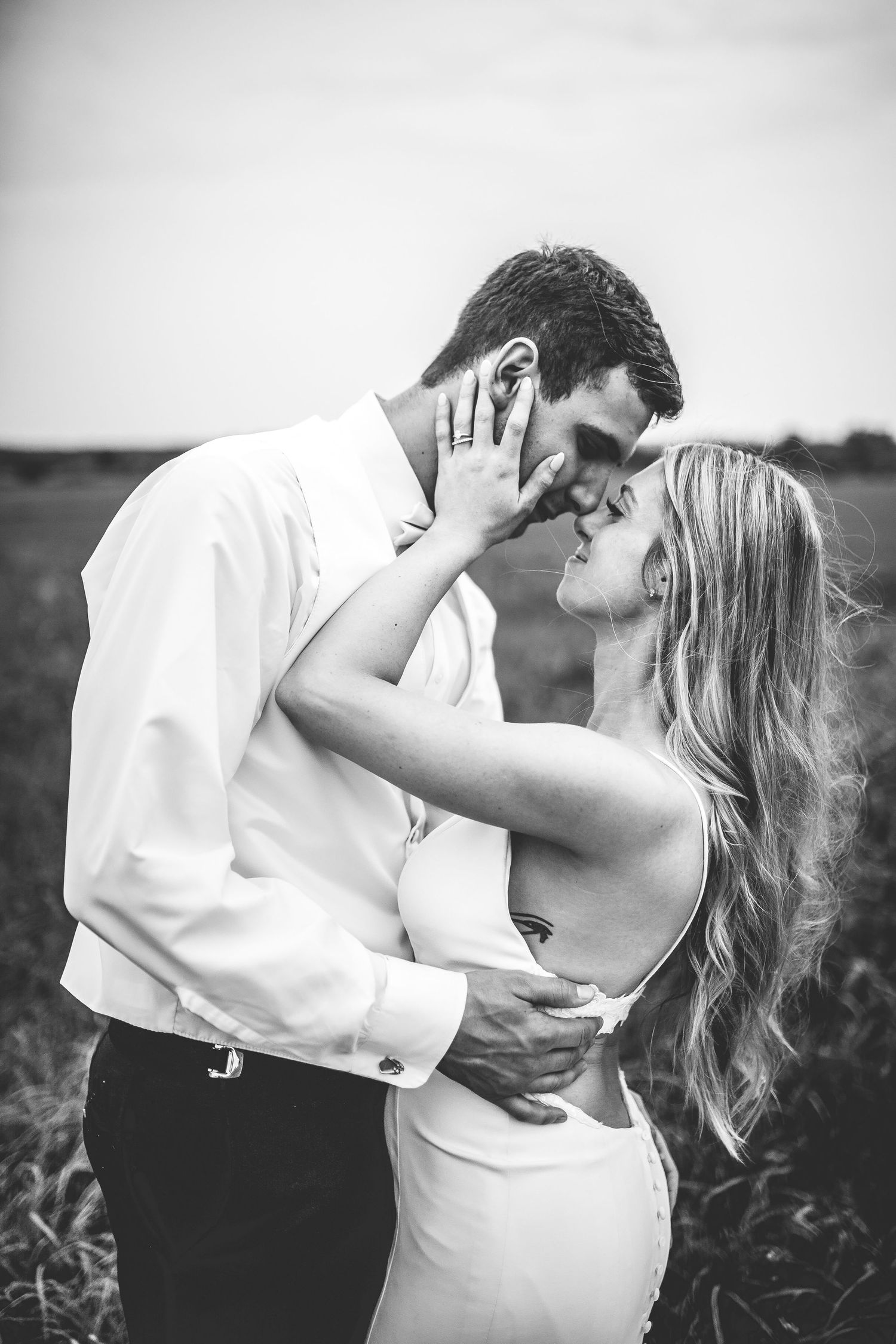 Intimate black and white wedding portrait capturing a tender moment in nature.