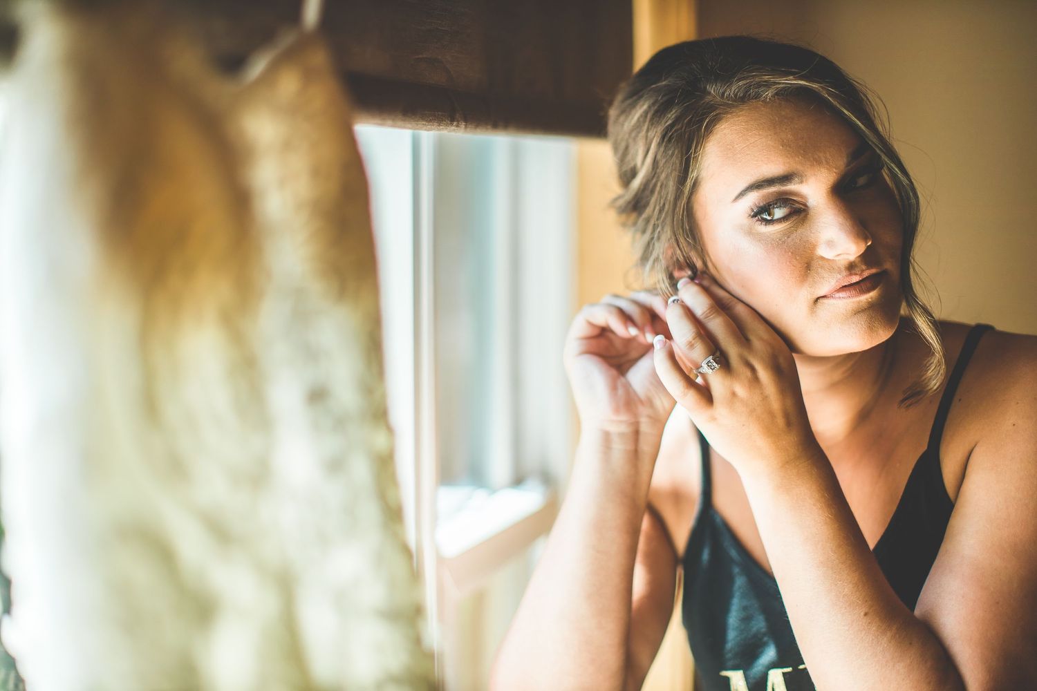Soft natural light illuminates getting ready moments through window.