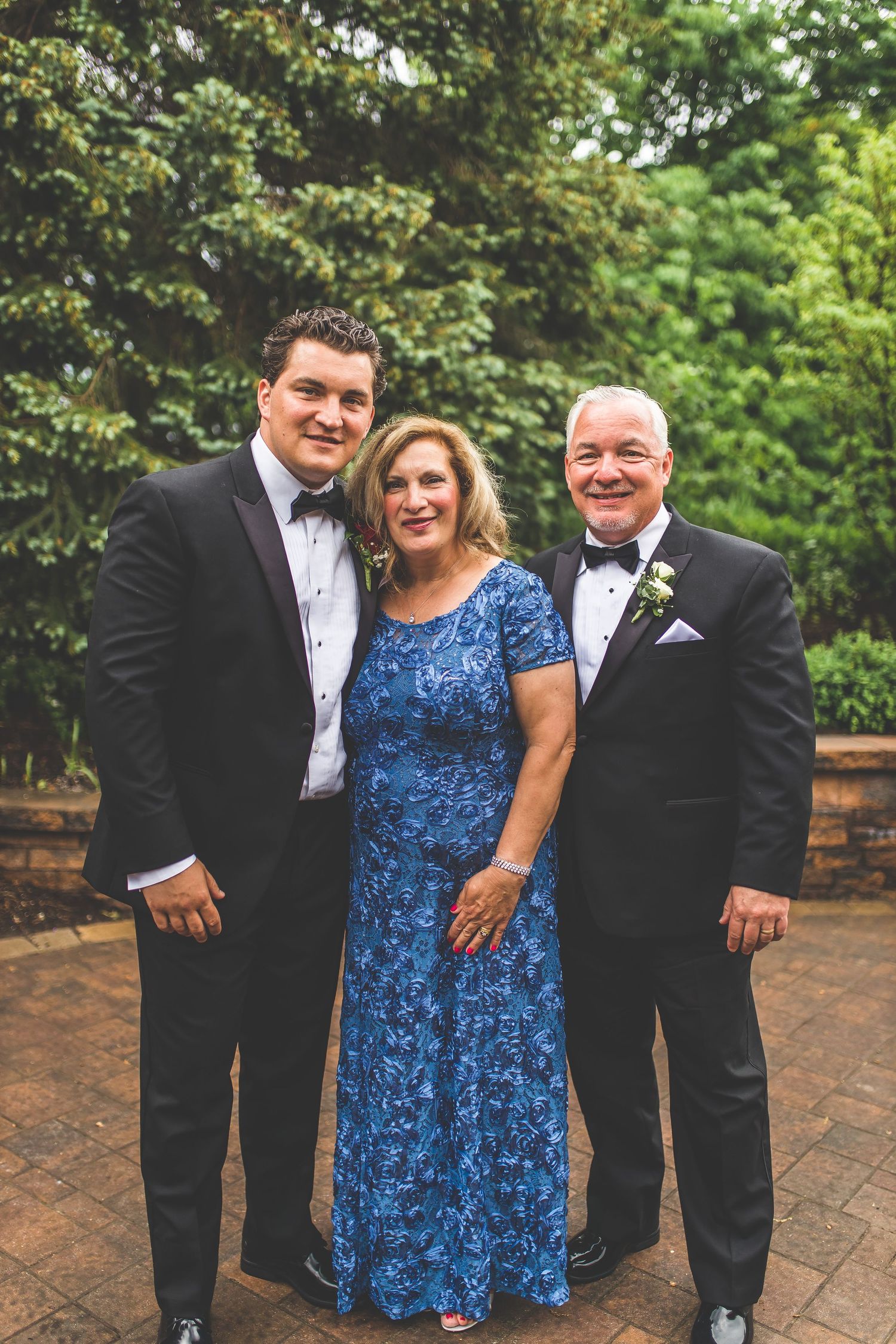 Group photo on brick patio with formal attire and blue dress accent.
