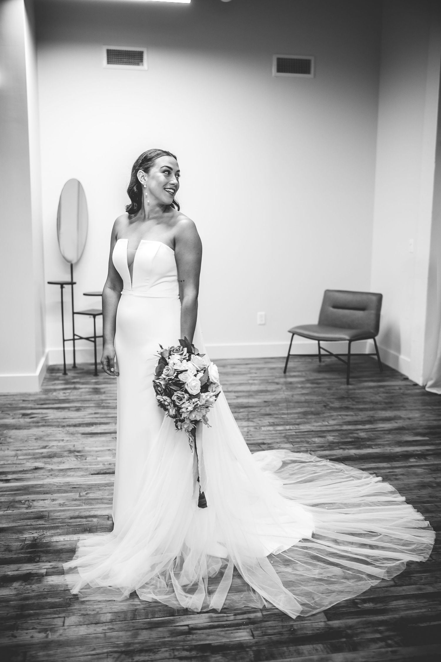 Black and white bridal portraits showing the movement and flow of a wedding dress in an empty studio space.