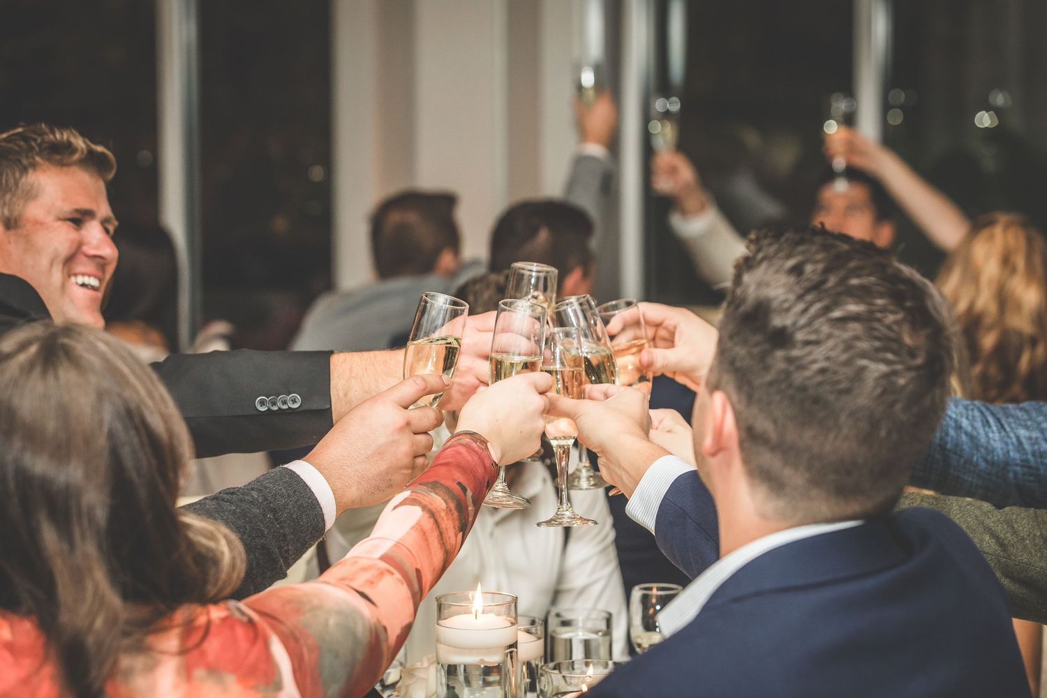 Wedding guests raise glasses for a celebratory toast during reception.