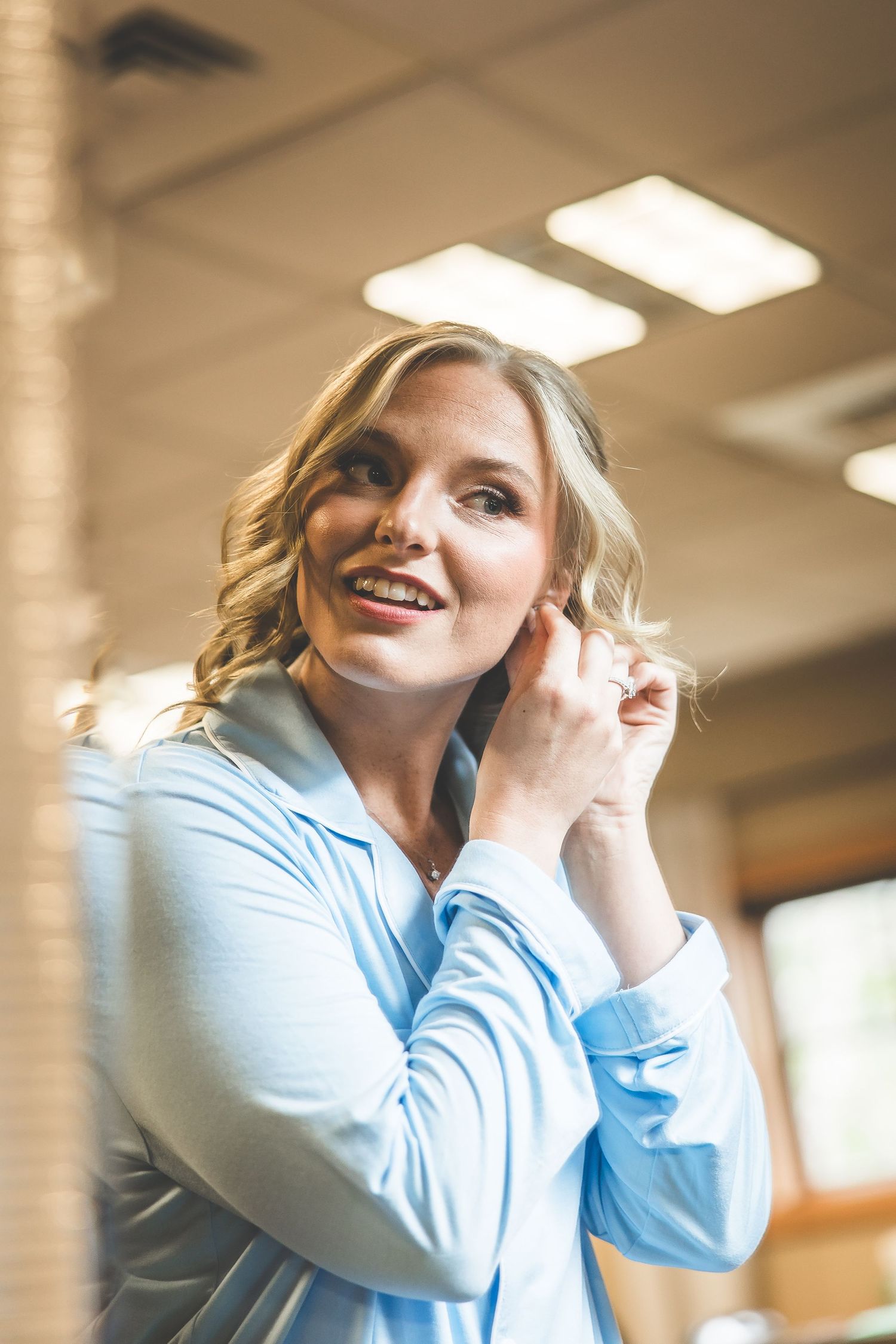 A sequence of emotional reactions showing laughter and joy in a light blue top against a warm indoor setting.