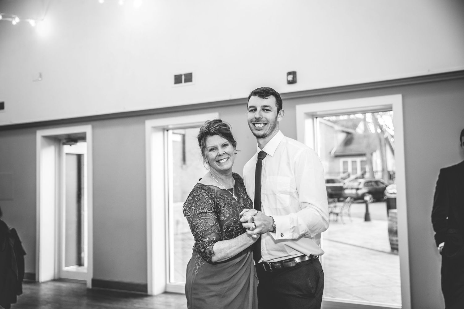 A black and white photo of a couple dancing together at an indoor event.