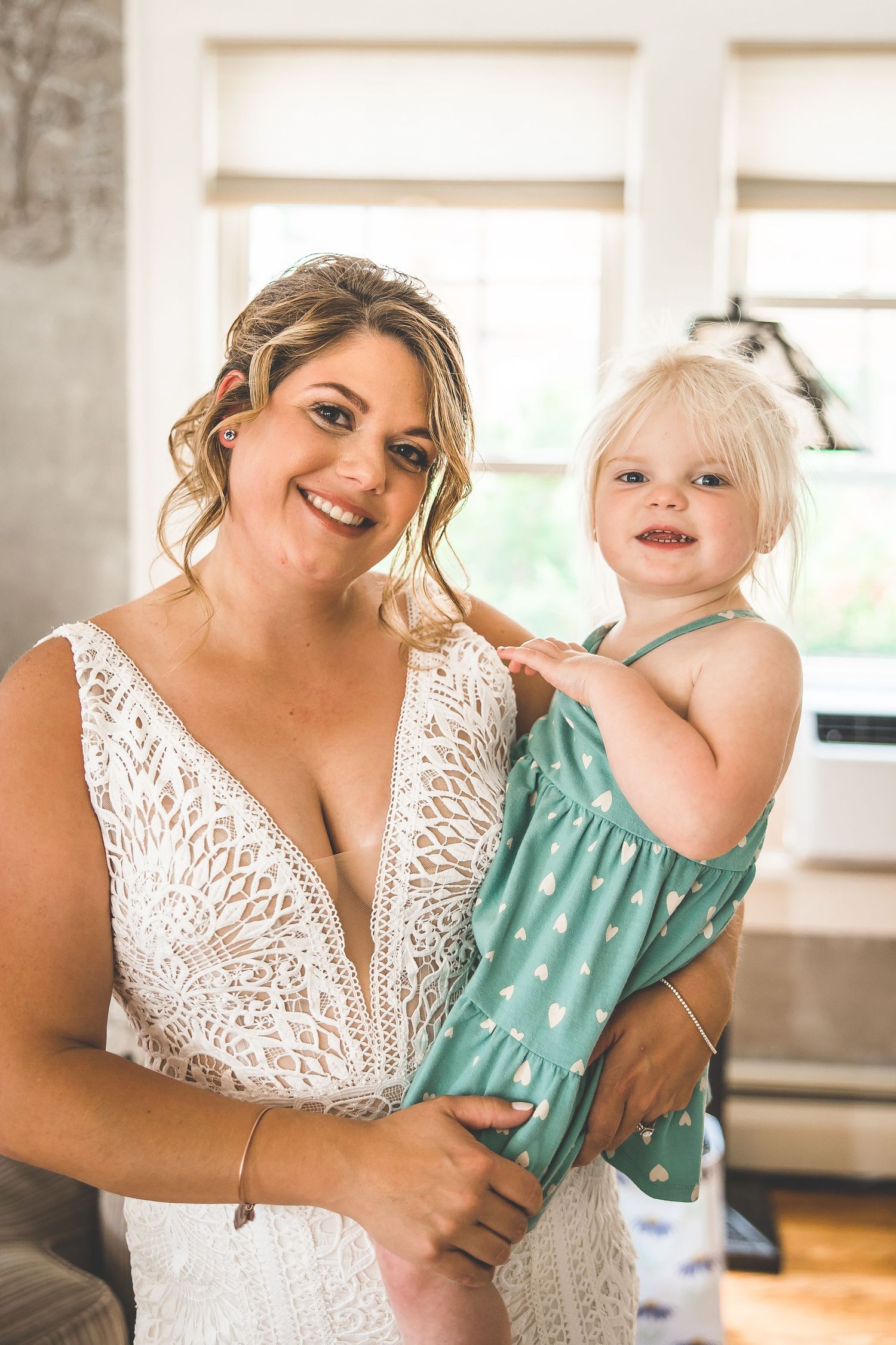 A tender moment between two people in a bright indoor setting wearing white lace and mint green.
