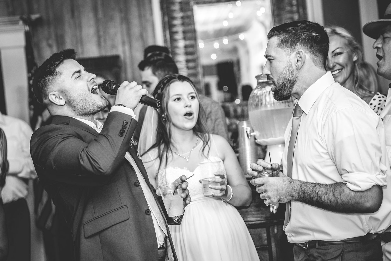 Wedding guests share emotional embraces and dances during the reception celebration.
