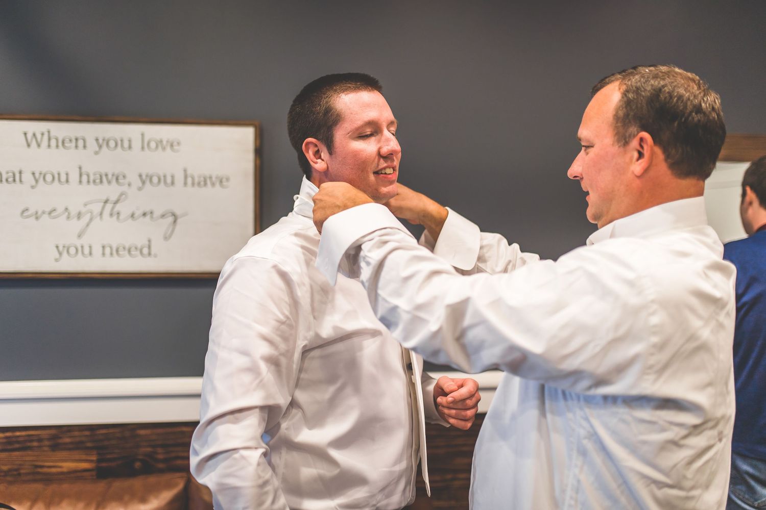 Groomsmen in white shirts sharing a celebratory moment before the ceremony.