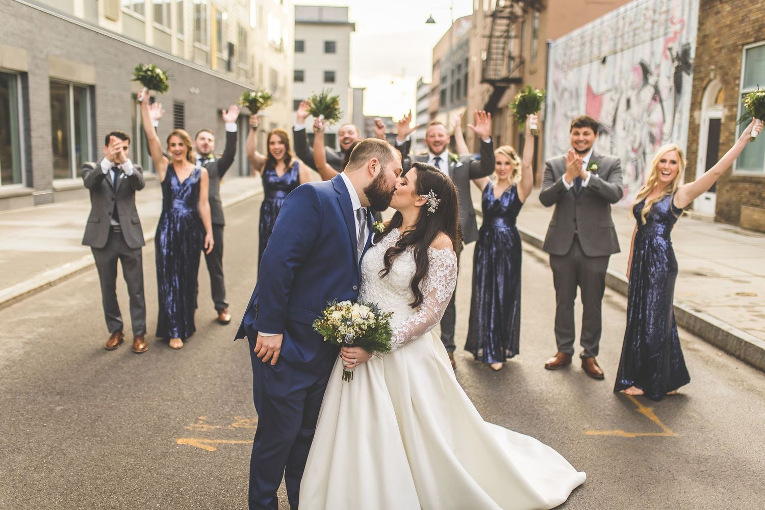 Wedding party walking down a city street in navy blue and white formal attire.
