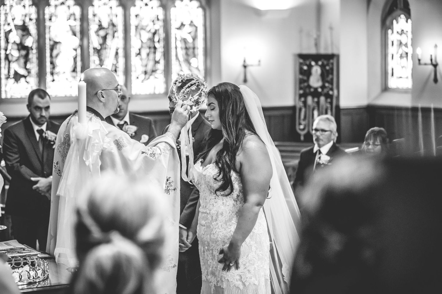 Black and white photo capturing an intimate moment during a church wedding ceremony.