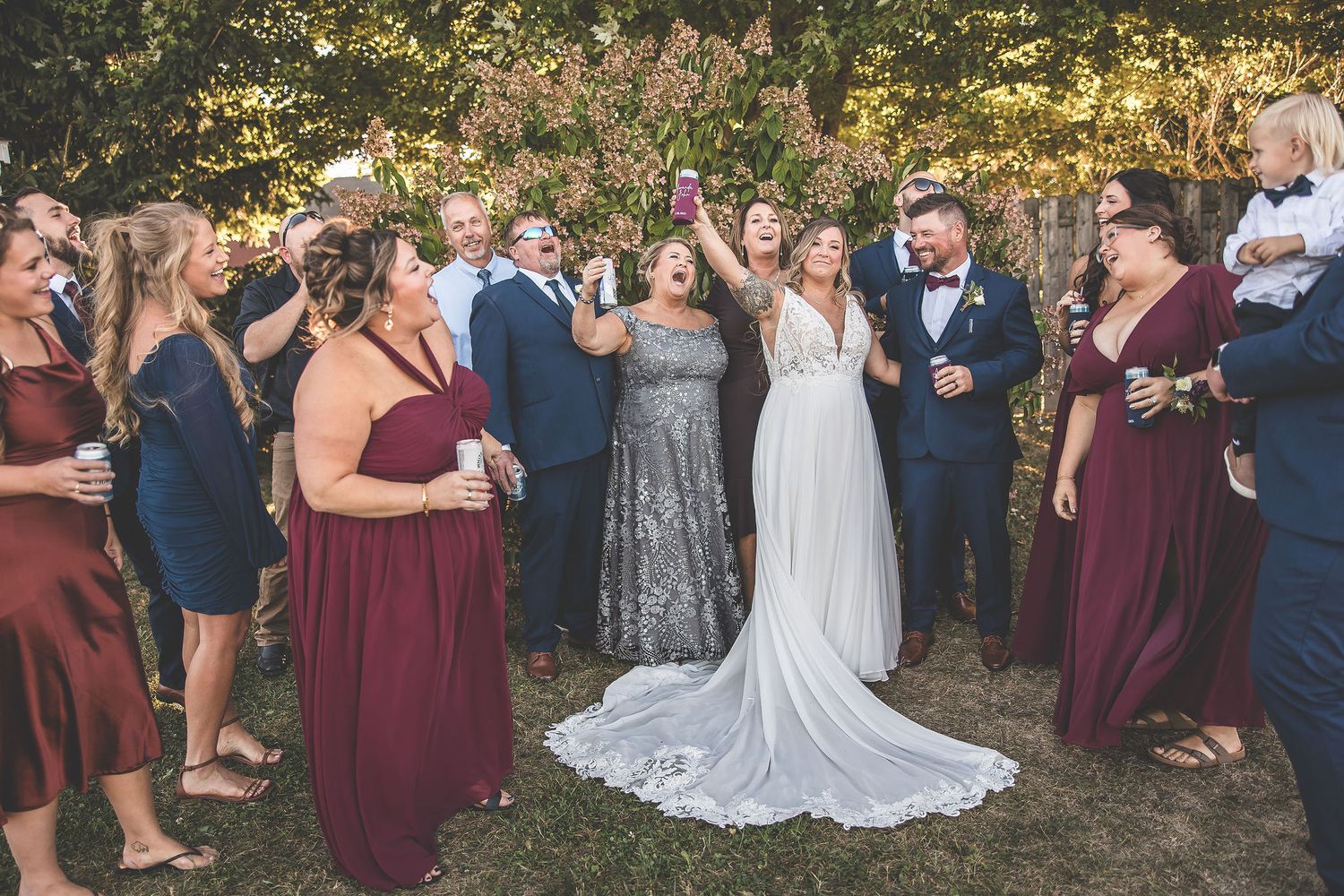 Wedding celebration group photos with burgundy and navy color scheme in outdoor setting.