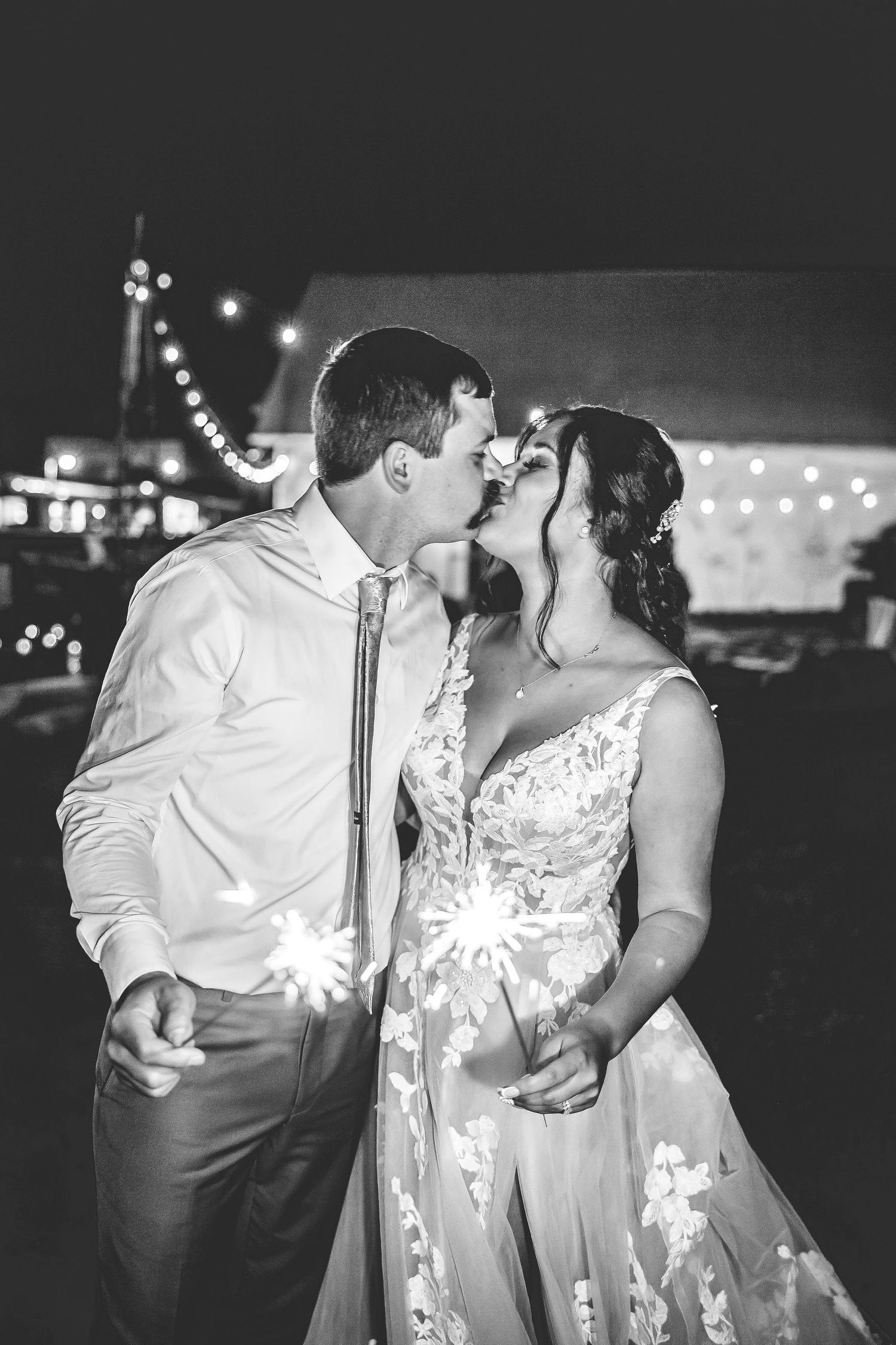 Romantic nighttime sparkler photos of couples during a wedding celebration.