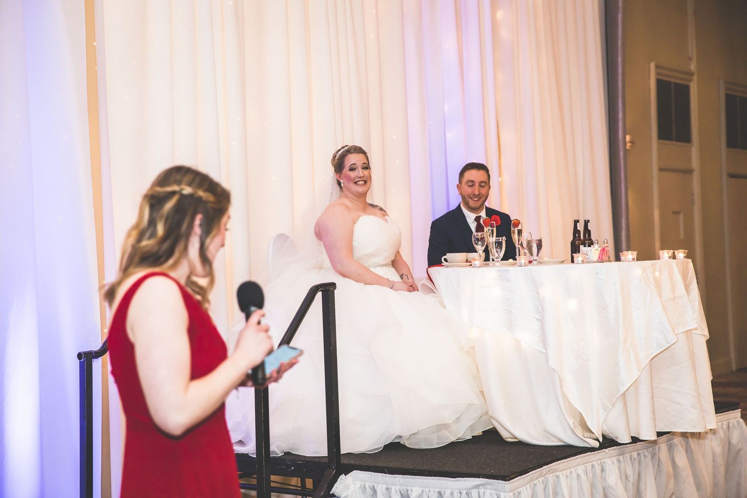 Wedding speech being delivered at head table during reception.