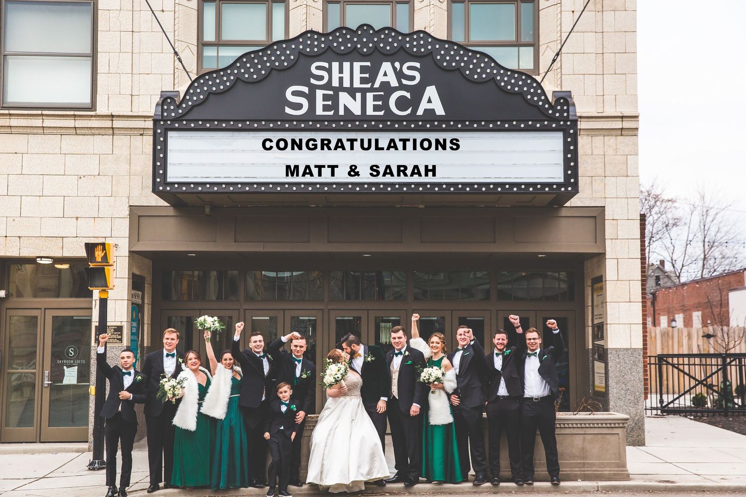 Wedding party posed in front of Seneca Theater with congratulatory marquee sign.