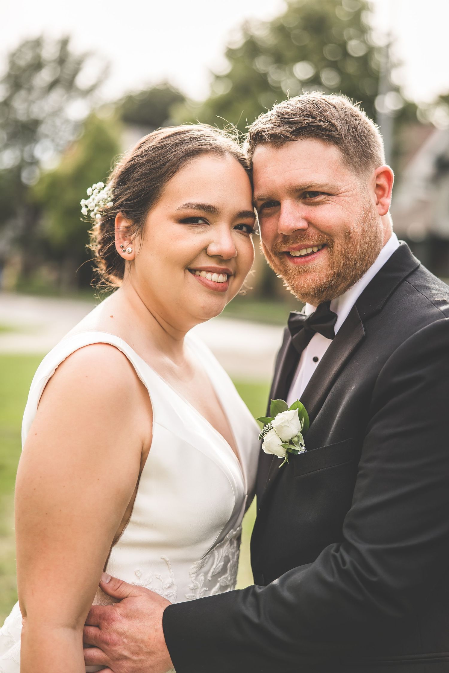 Candid wedding portraits showing tender moments between newlyweds in outdoor setting.