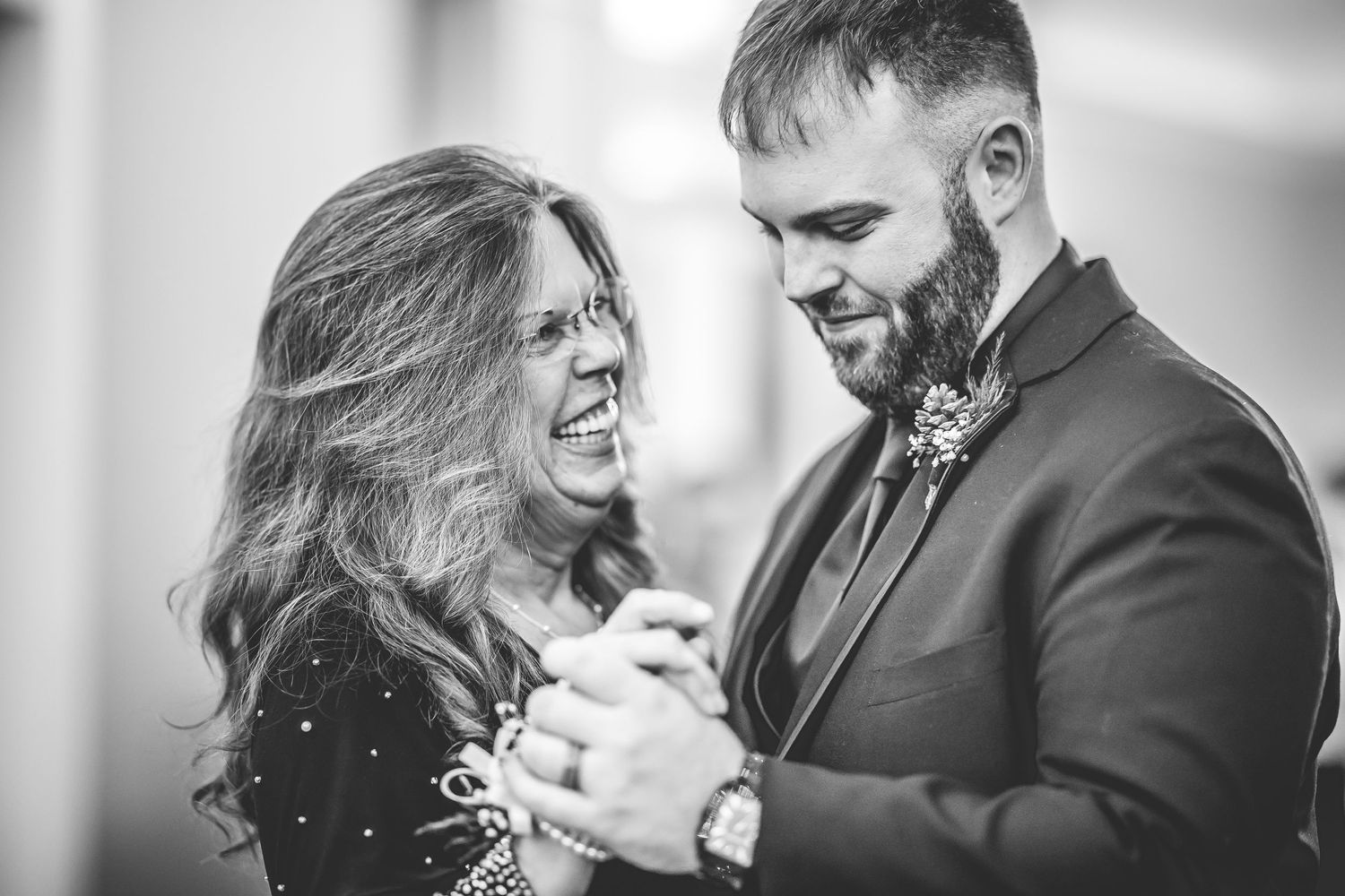 Black and white candid shots of a joyful first dance at an elegant wedding reception.