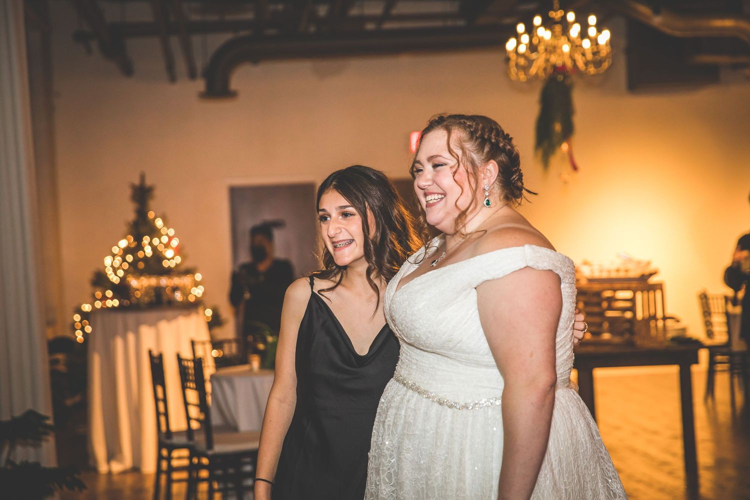 Wedding party dancing and celebrating in an elegant venue with warm lighting.