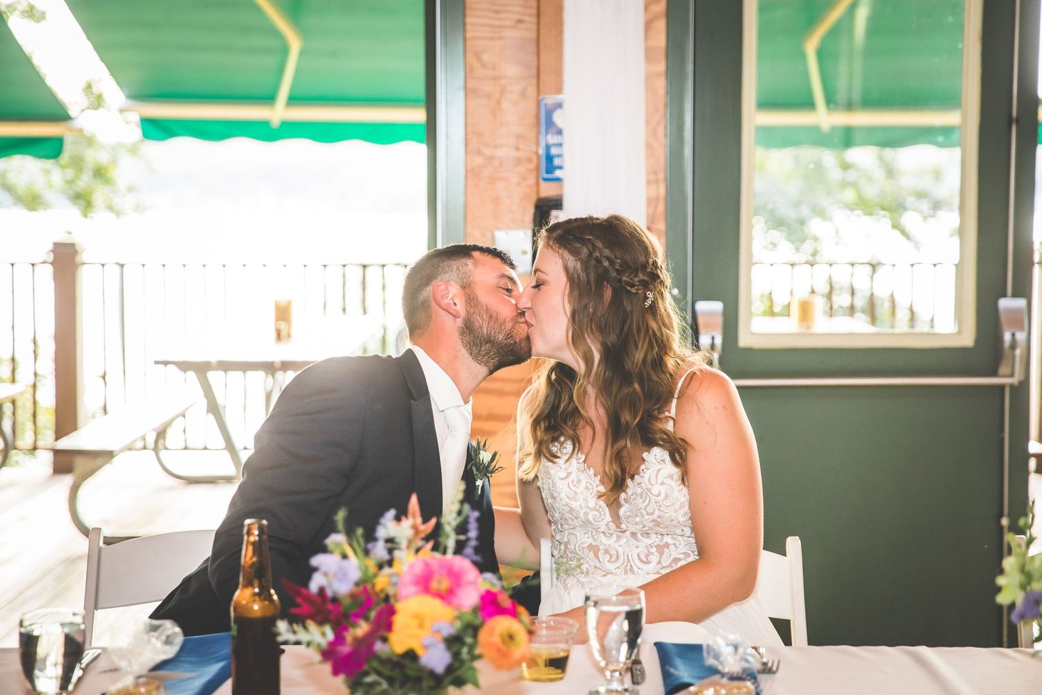 Sunlit wedding reception venue with bright windows and floral centerpieces.