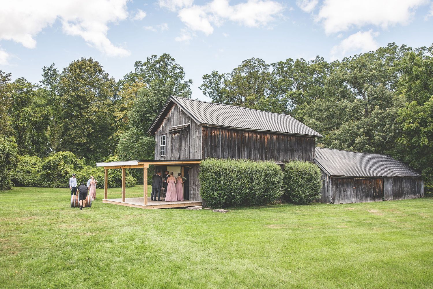 Panoramic view of a rustic barn venue with rolling hills in the background.