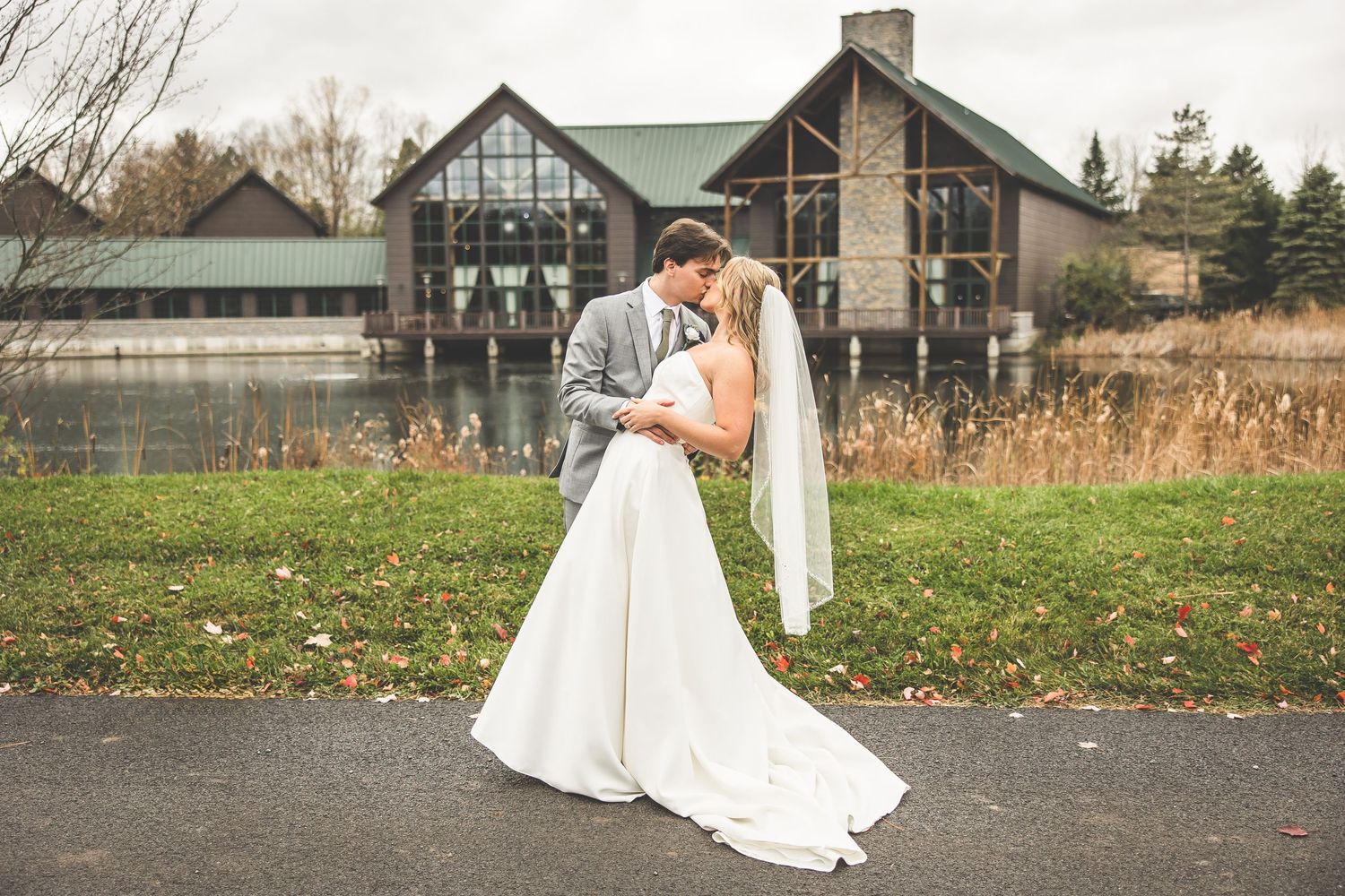 Wedding venue exterior with Tudor-style architecture surrounded by fall foliage.