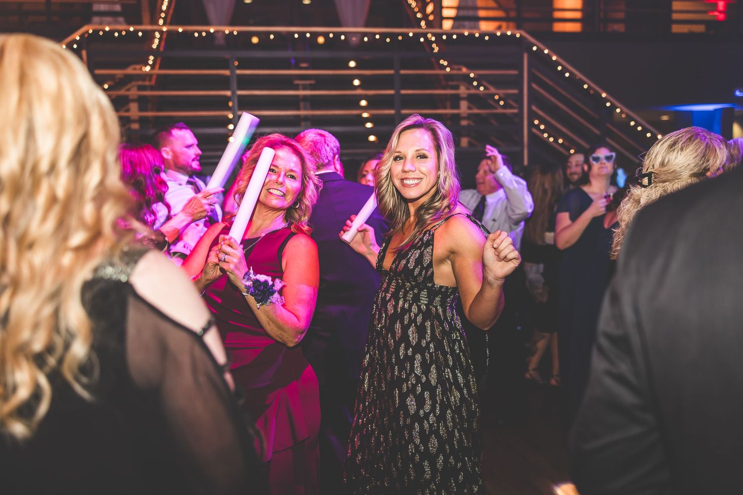 Wedding reception dance floor with colorful lighting and string lights creating a festive ambiance.