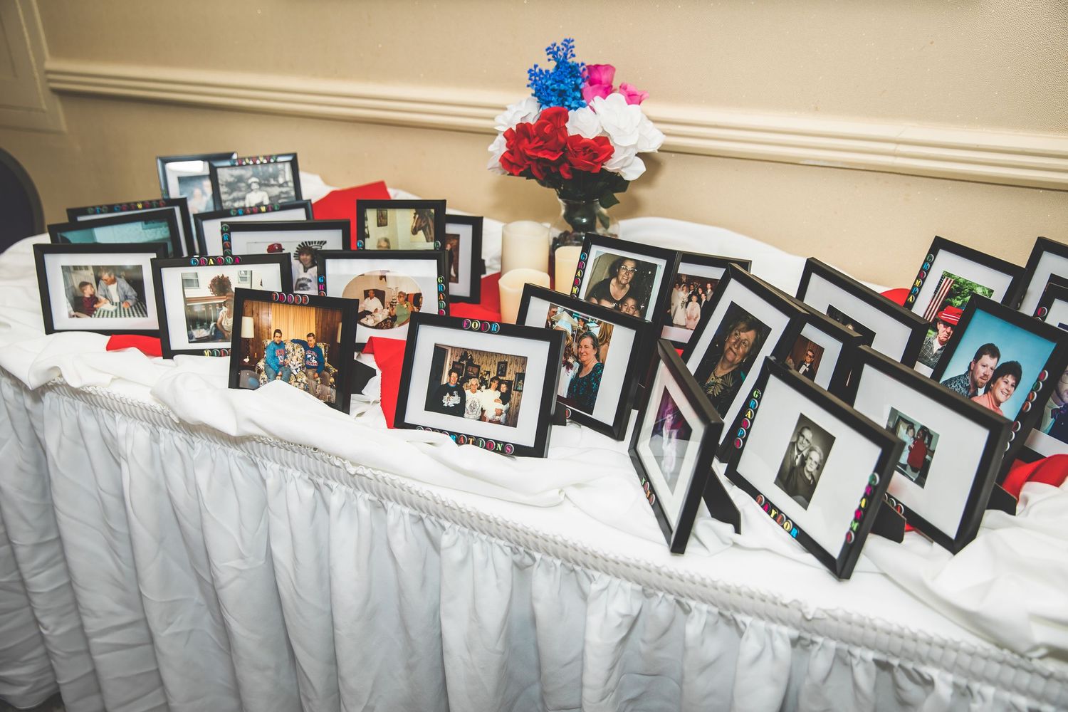 Display of black-framed photos arranged in a diagonal pattern along a wall.