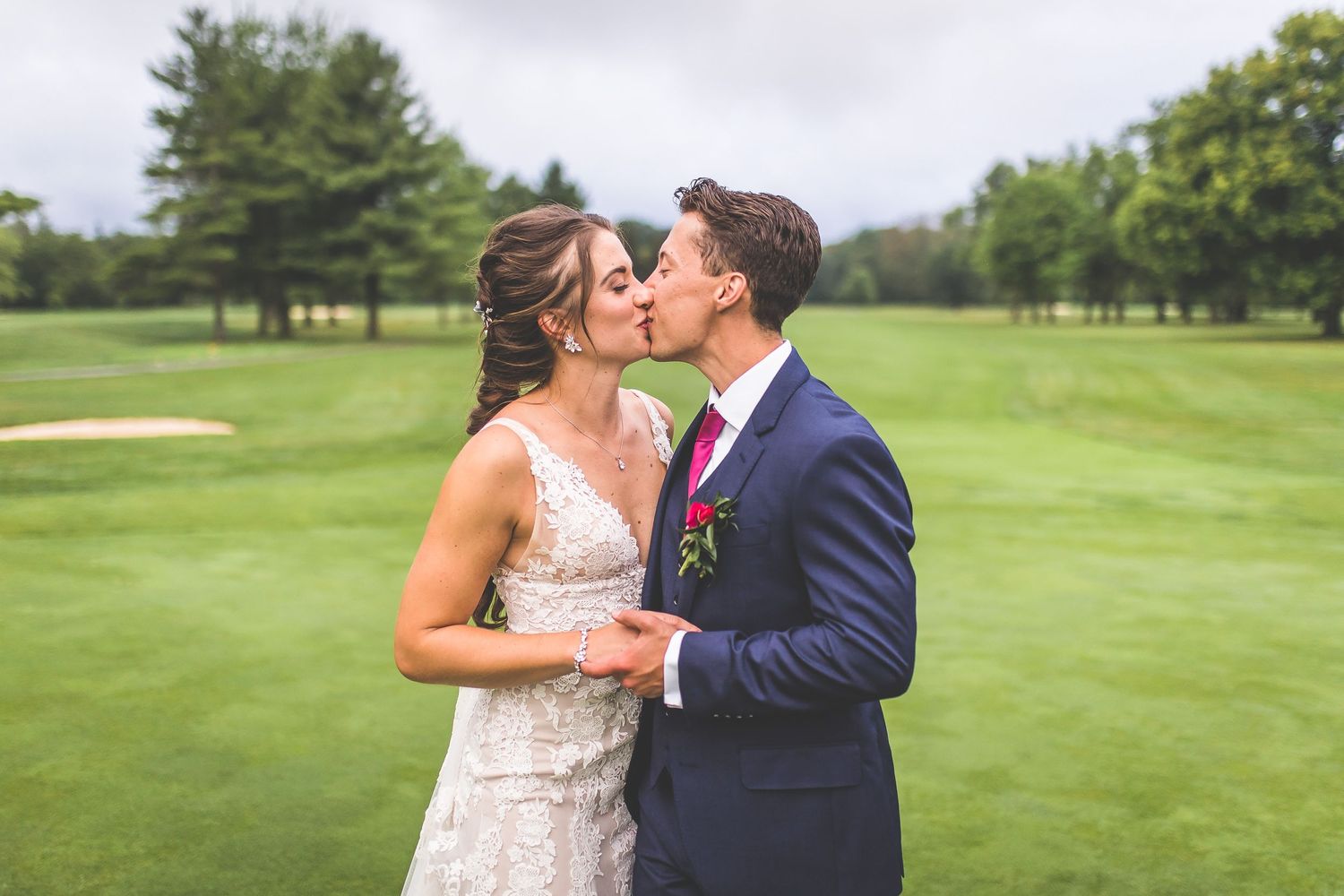 Couple embracing on golf course greens during their wedding photo session.