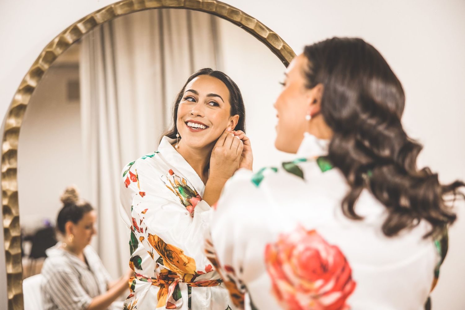 Group wearing floral robes laughing and celebrating in preparation room.