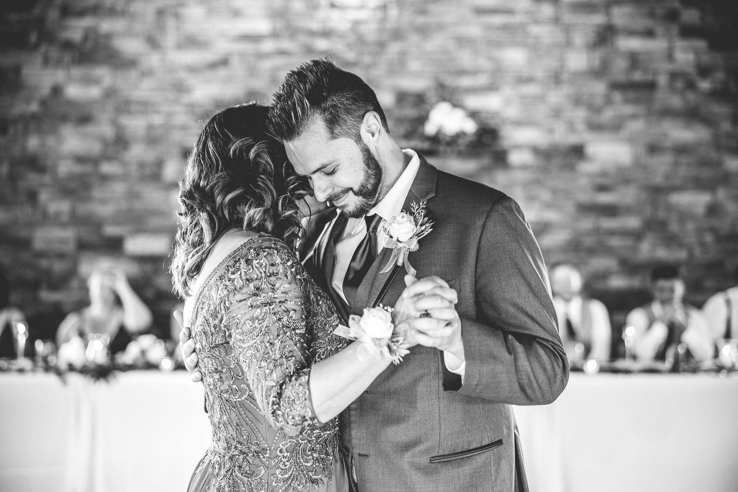 Black and white photo of a couple dancing at their wedding reception.