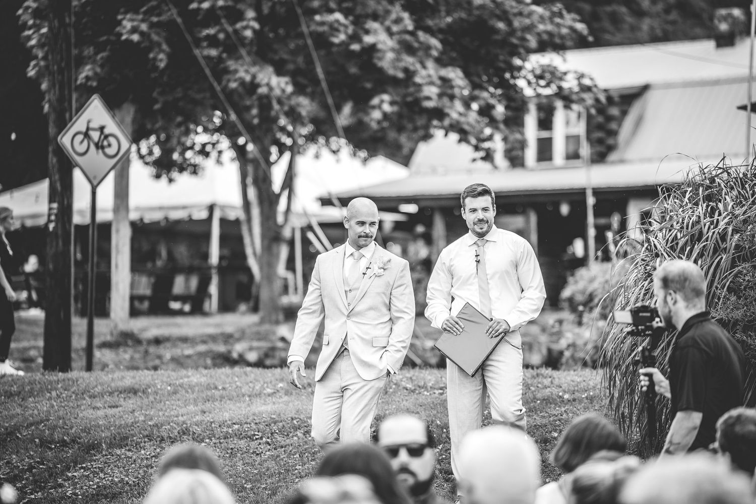 Outdoor wedding ceremony setup with white chairs and floral arrangements.