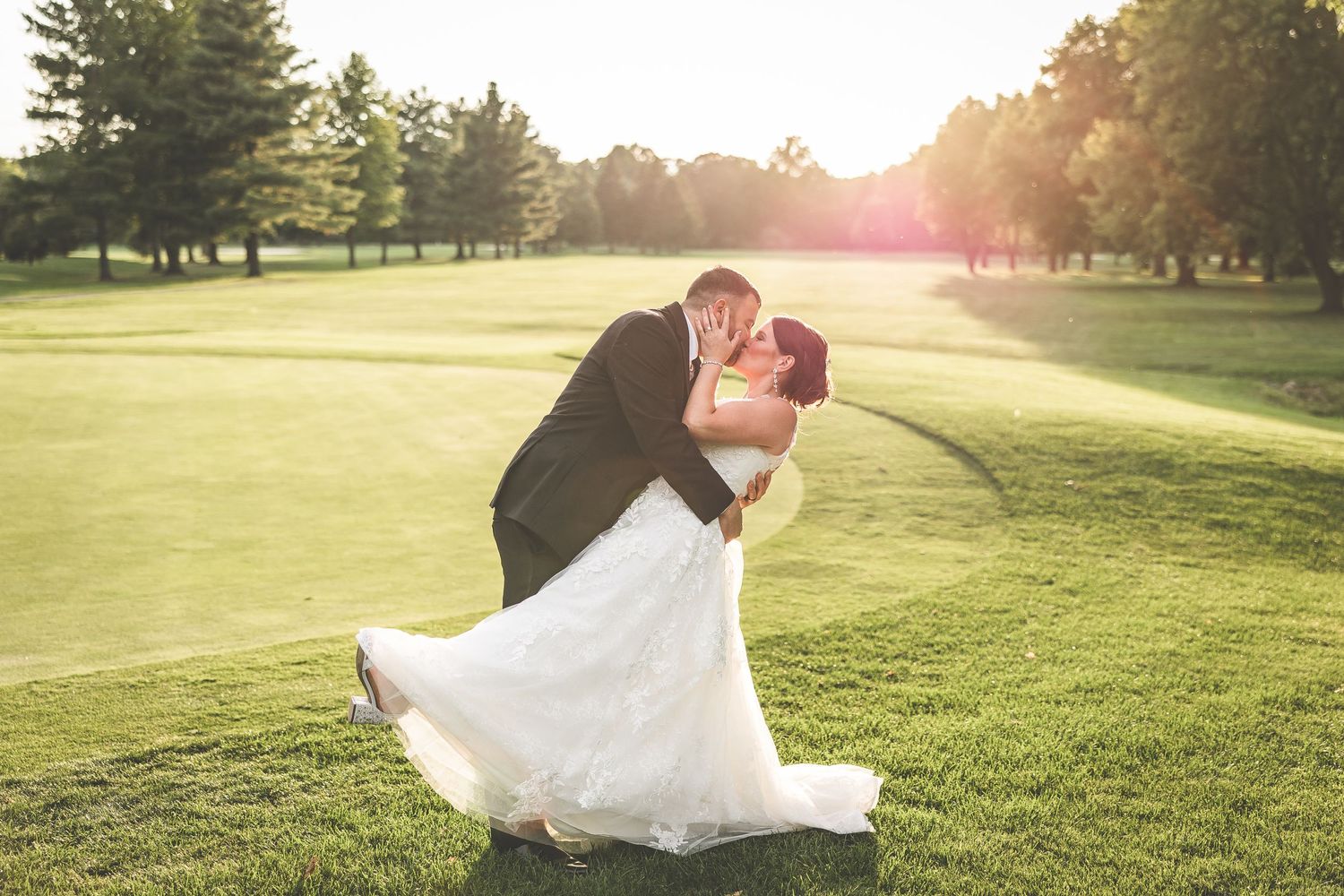 Romantic sunset wedding photos on rolling green golf course hills.