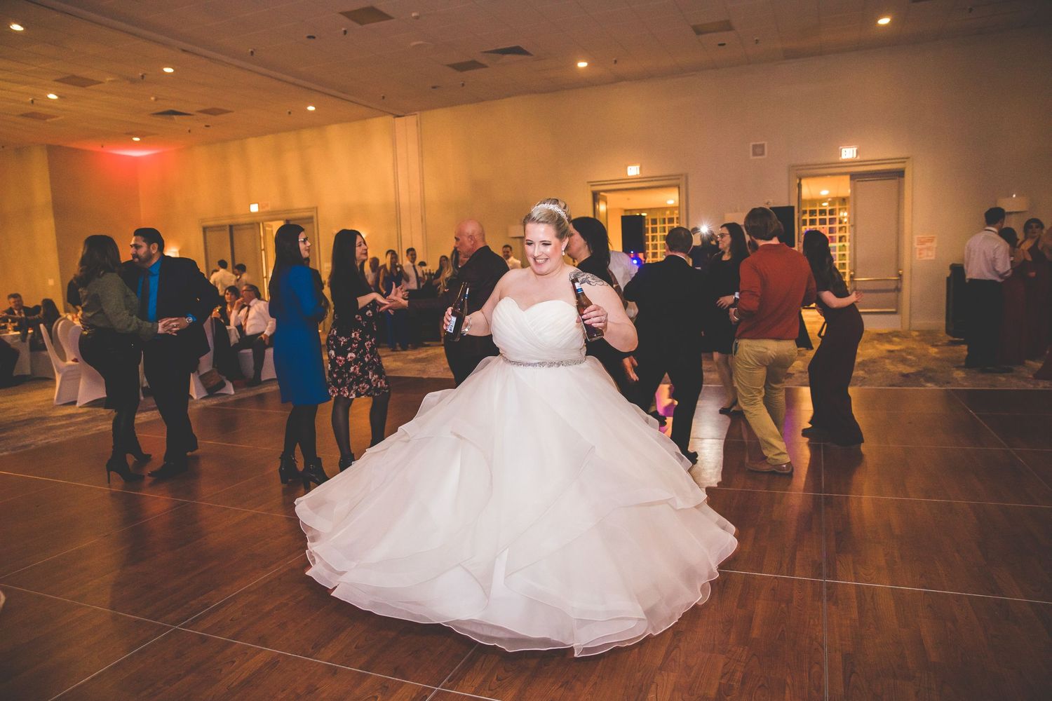 Panoramic view of wedding reception dance floor with guests celebrating in elegant ballroom.
