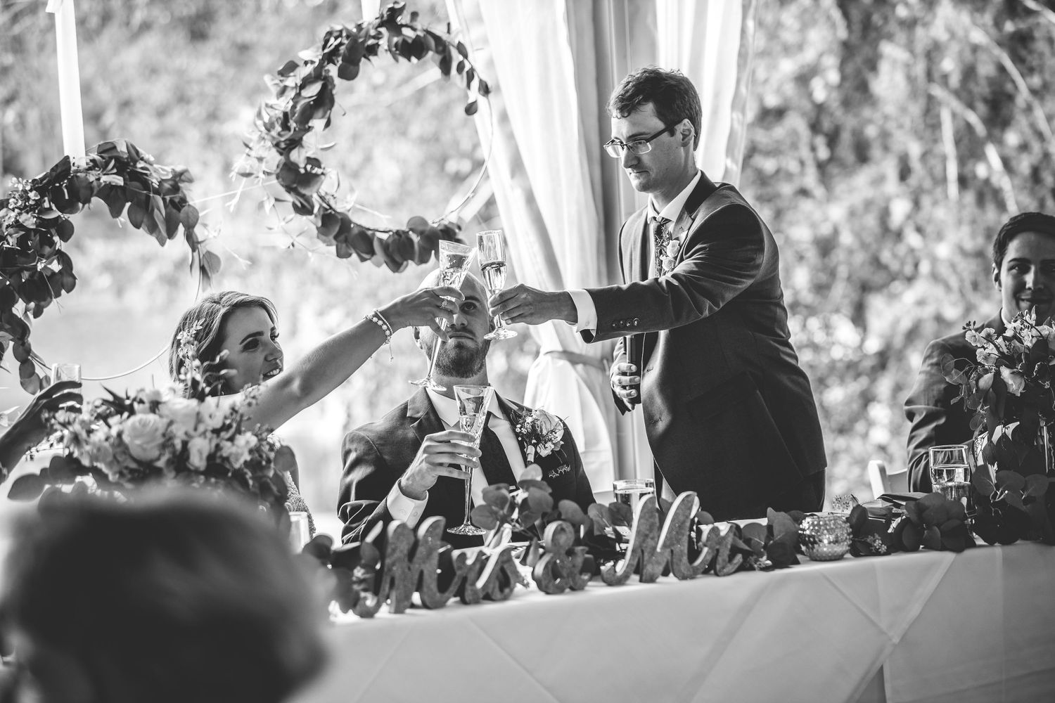 A black and white photo of a wedding toast at an elegant reception.