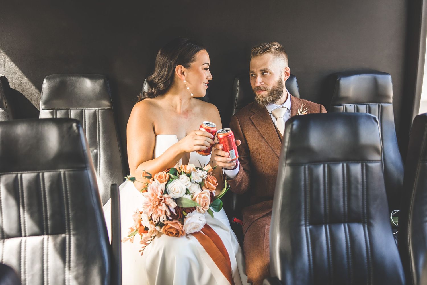Candid wedding moments captured inside a vintage car with leather seats.