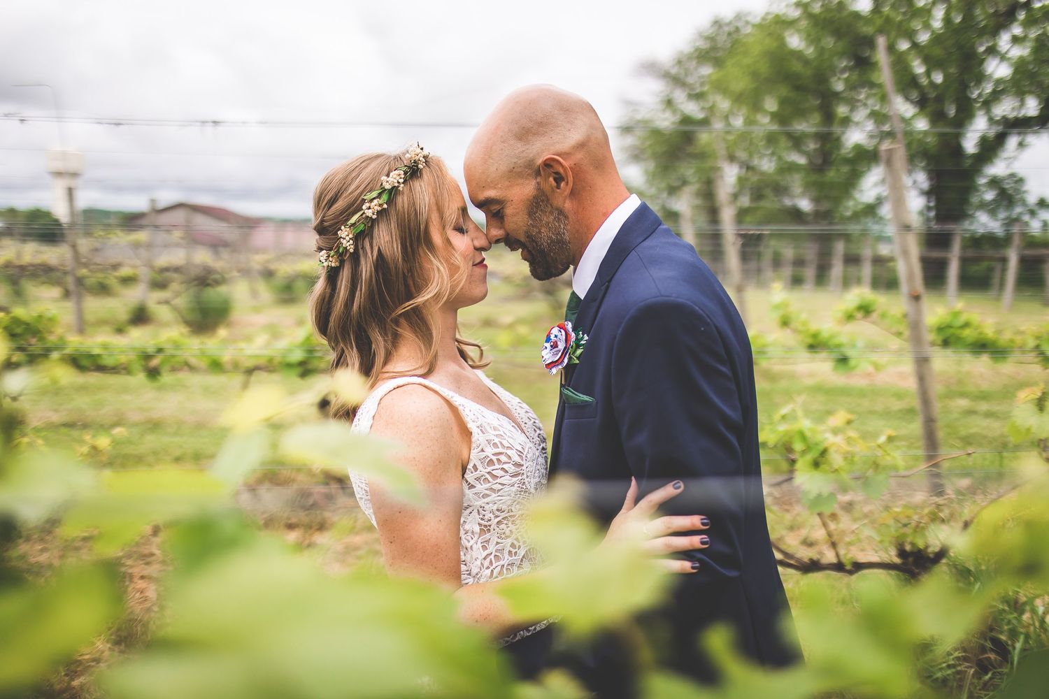 Candid wedding photography shows couple's natural interactions among vineyard greenery.