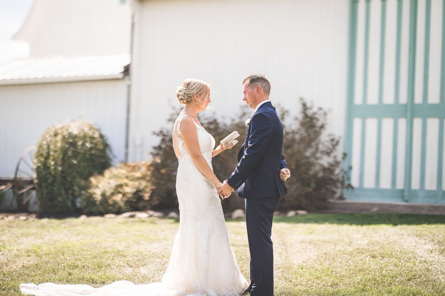 Wedding couple poses for portraits outside a white building with turquoise trim.